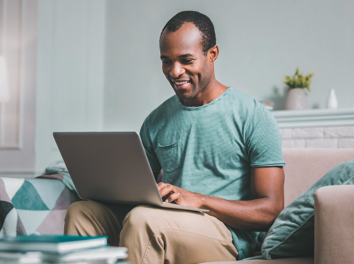 A man sits at a laptop using the internet. 